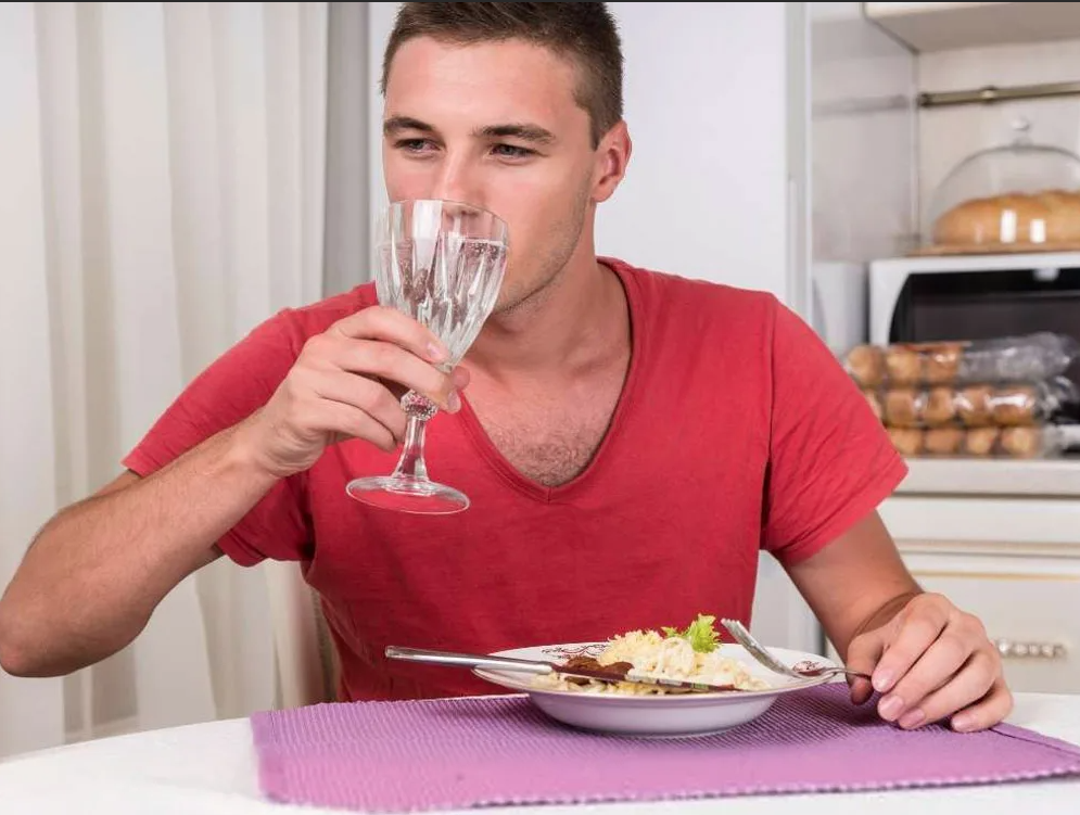 Можно запивать водой во время еды. Запивать еду. Мужчина обедает. Запивать еду вредно. Еда и питье.